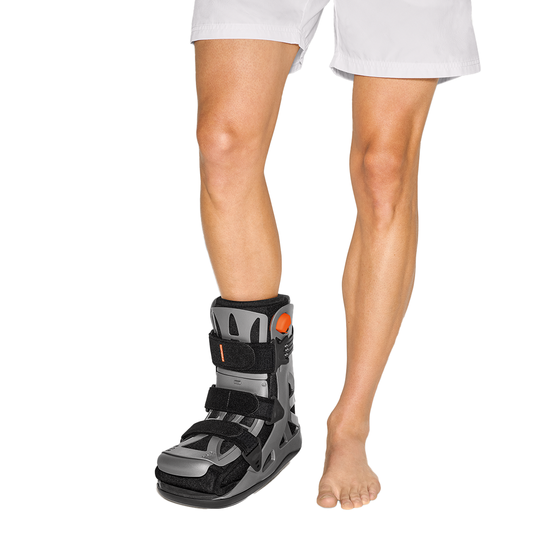 Person wearing a black orthotic boot on a white background