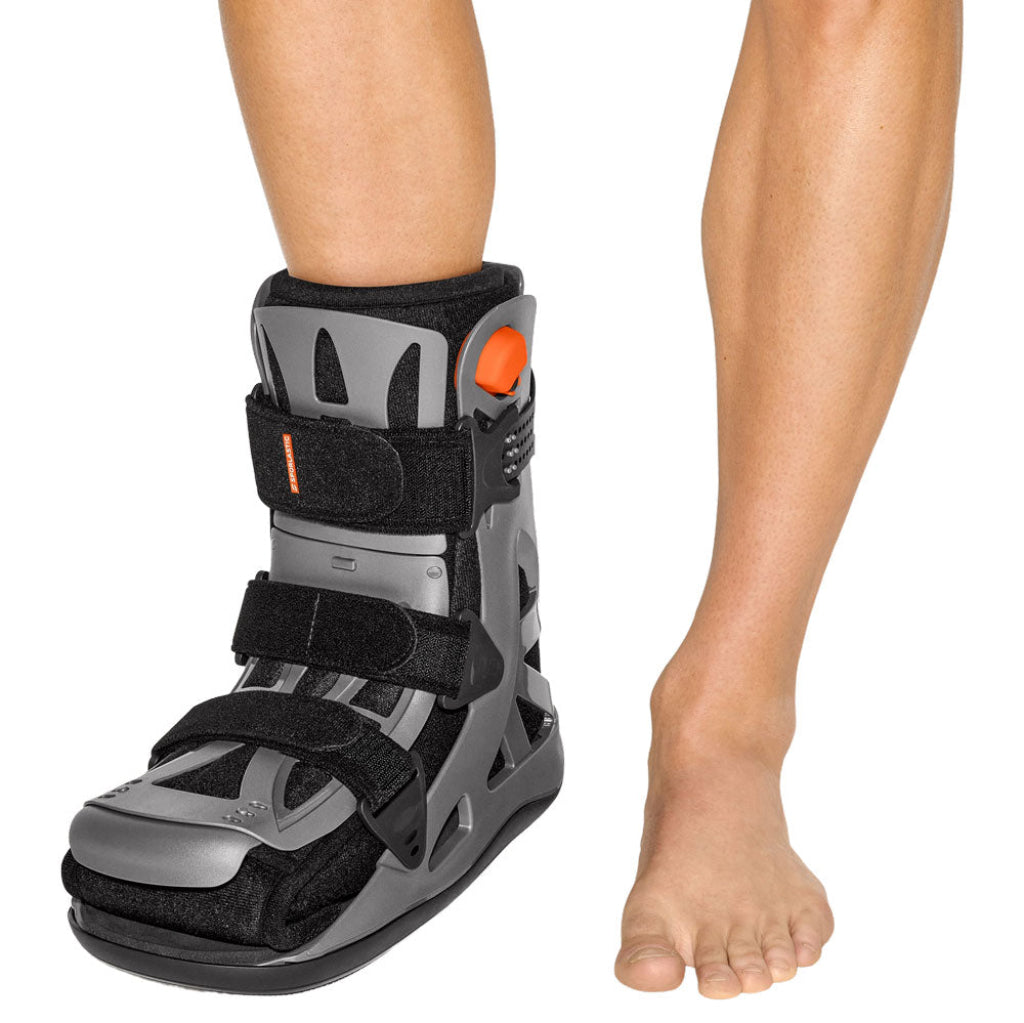Gray and black orthotic foot brace walker on a person's foot against a white background