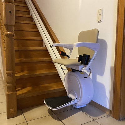 Stairlift attached to a wooden staircase in a home setting
