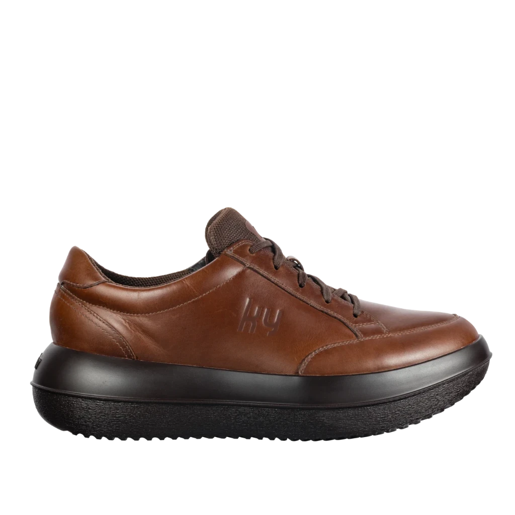 Brown leather shoe with black sole on a white background